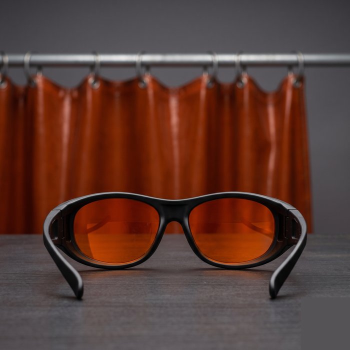 Óculos de proteção para laser de fibra ao lado de uma cortina de proteção
